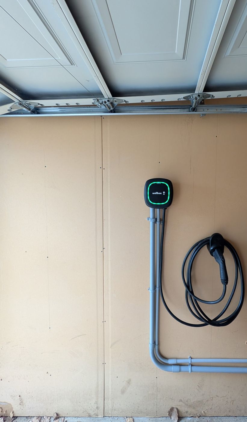 Professional Level 2 EV charger installation in Edmonton showing clean EMT conduit run and Wallbox Pulsar Plus mounting completed by Red Seal Master Electrician at Stellar Upgrades