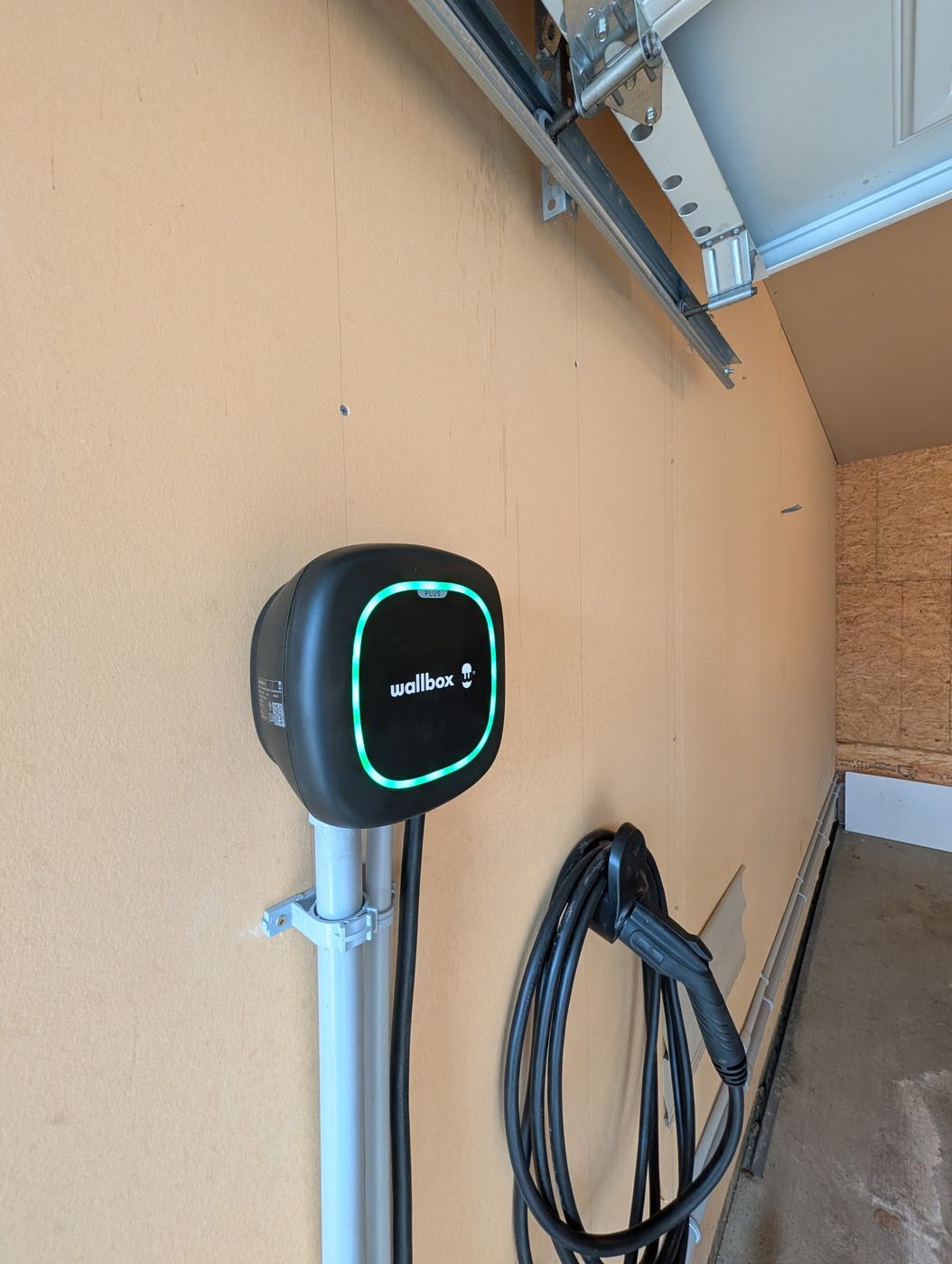 Wallbox Pulsar Plus EV charger installed by Stellar Upgrades in an Edmonton garage with active green status indicator