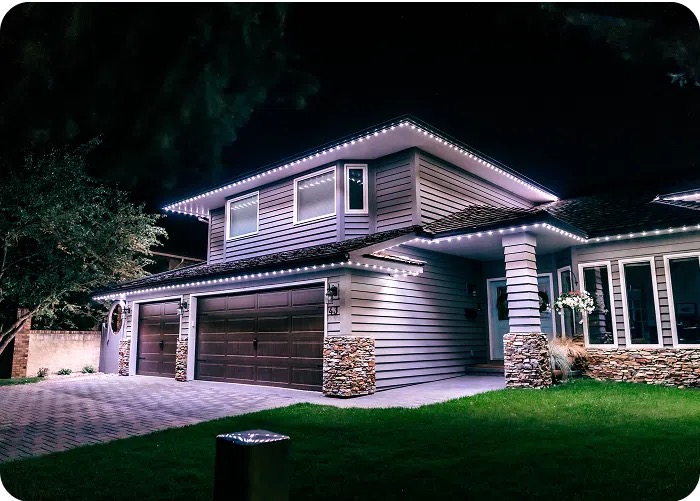 Modern two-storey home and garage at night with crisp white permanent lighting