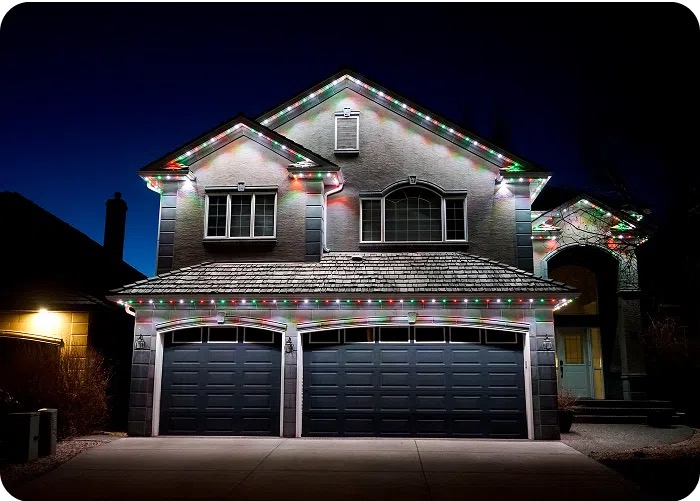 Two-storey home lit in red, green and white for Christmas with permanent lighting