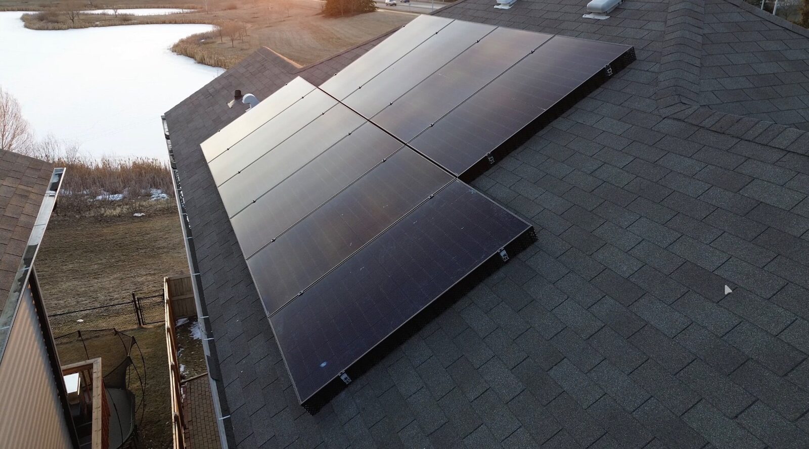 Residential solar panels at golden hour on an Edmonton home overlooking a pond